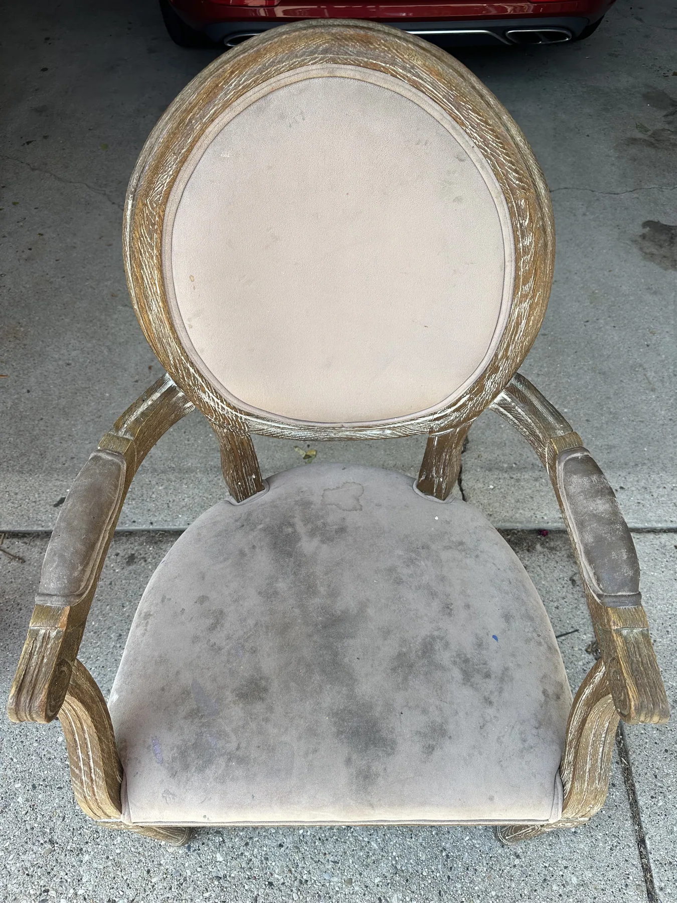 Upholstered French-style armchair seat with dark ground-in dirt before dry cleaning