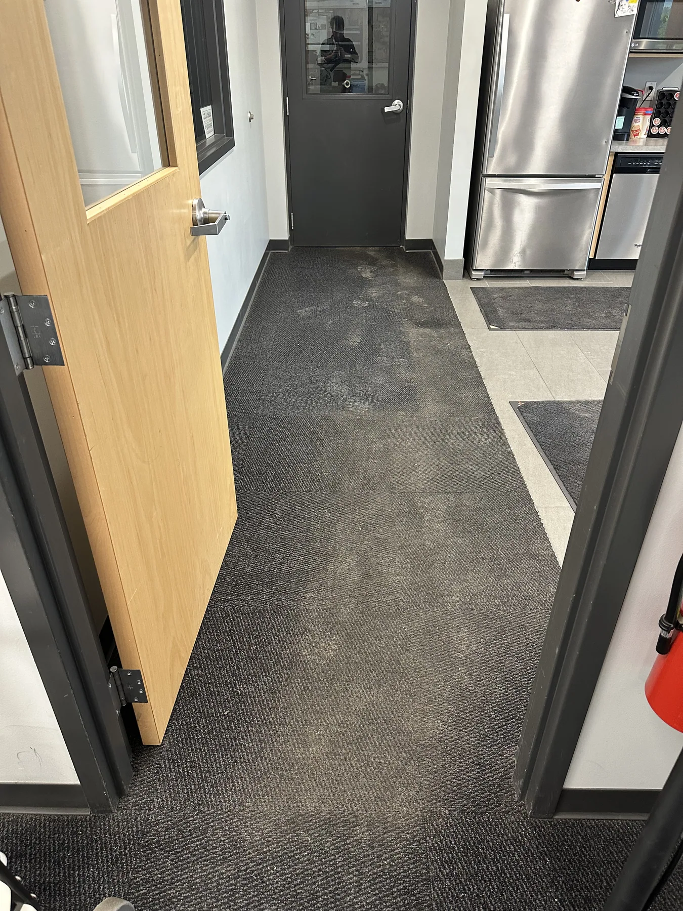 Commercial kitchen hallway carpet with visible traffic soil before dry cleaning