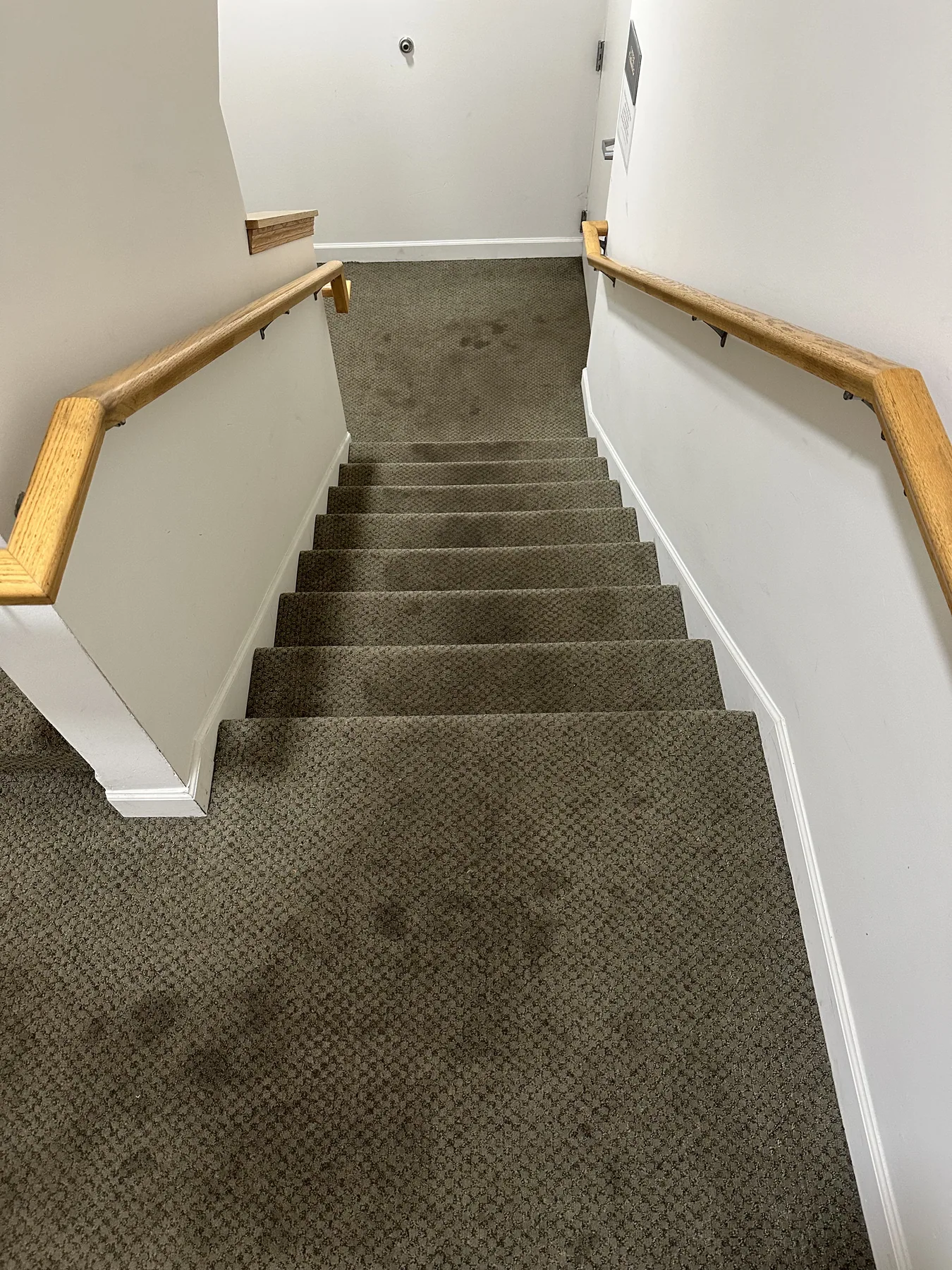 Residential staircase and landing carpet with visible dark soiling before cleaning