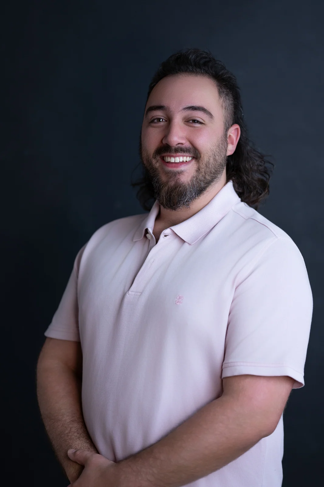 Tim Lazaris, owner of Top Hat Carpet Cleaning, smiling in a light pink polo